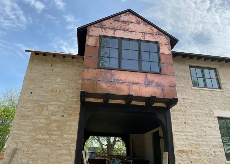 Copper metal panel facade on a stone building for Roof Repair in Enterprise